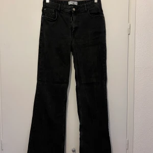 Svarta jeans - Svart/grå jeans i högmidjad bootcut modell från Mango. Fint men använt skick. För mer information och bilder kontakta mig.