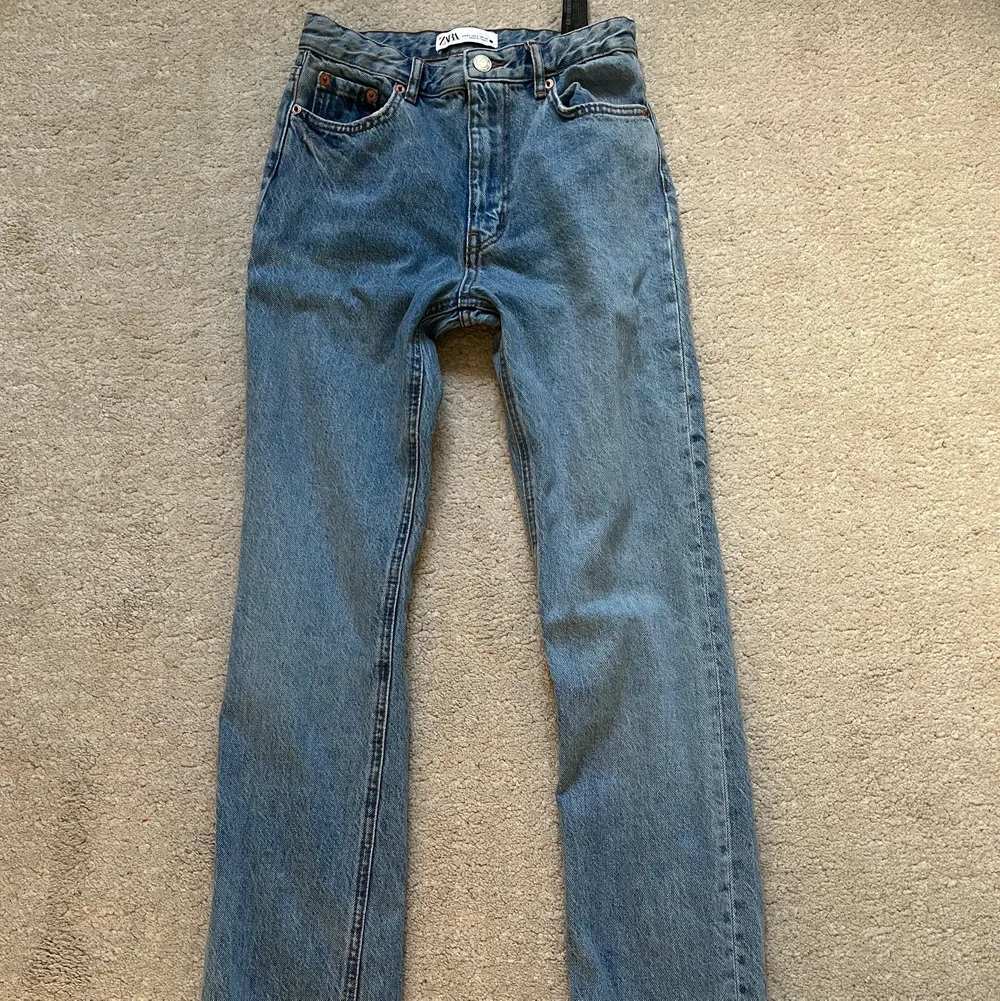 Ett par jeans med slits från zara. De har en straight modell och är i storlek 34. Använda 1 gång så jättebra skick!. Jeans & Byxor.
