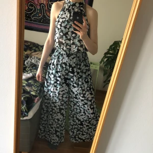 Luftig byxdress - Endast använd en gång på bröllop. Jag på bilden är 175 cm och för mig är den bra i längd. Mycket luftig och fint fall. Knytning i nacken. Resår i midjan. 