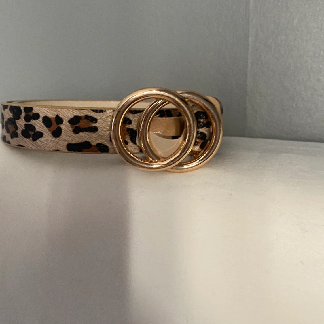 Skärp leopardigt me guldigt spänne. 