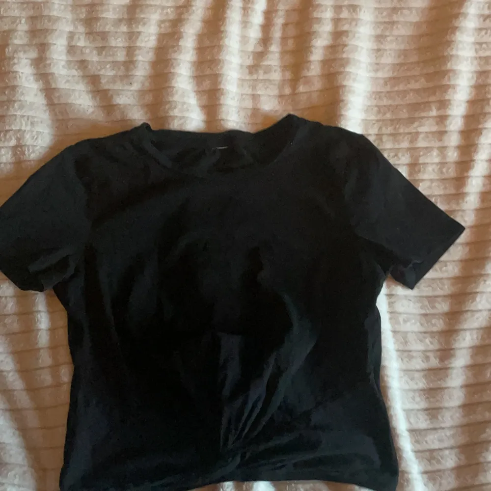 En svart H&M T-shirt med knut längst ner⚡️ Avklippt lapp men är nästan säker på att den är storlek 146/152.💞. T-shirts.