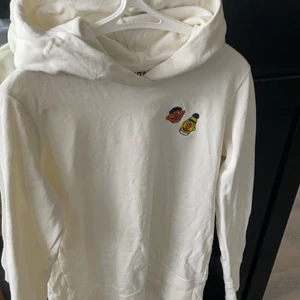 Kaws Sesamestreet hoodie - Kaws Sesamestreet hoodie från uniqlo. Använt en gång. Beige/vit färg. Storlek M men sitter som S.