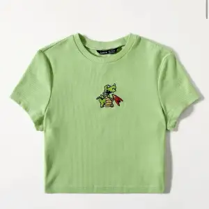 En grön stretchig tröja med en drake på. Den är i storlek M men den passar Som en S och XS också.pris kan diskuteras 