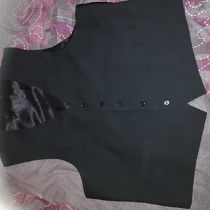 Väst 2XL - Svart svädt med satin liknande tyg bak till och invändigt knappt använd svarta knappar ett litet spene i ryggen  från dresman storlek 2XL.  Frakt till komer