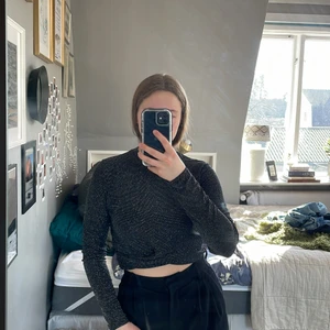 Glittrig festtopp från Hm strl L - Jättefin festtopp från Hm. Glittriga tygdetaljer med svart ”bakgrund”. Snygg ”Knut” på tröjan som lovar upp den. Storlek L. Säljer pågrund av att den är för stor för mig. Endast använd en gång. 50kr + halva frakten❤️