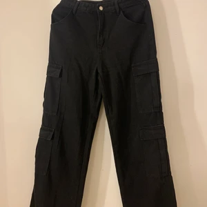 Svarta cargopants - Helt nyköpta byxor, använda 1 gång men visade sig inte sitter bra runt om midjan på mig, därför skriver jag måttet här nere så ni kan säkert kolla att dessa passar just dig! Längd: 133 cm midja 75.5 cm höft: 102 cm och lår: 63.2 cm🤍 sitter snyggt runt om och långa i benen, jag är 180! 