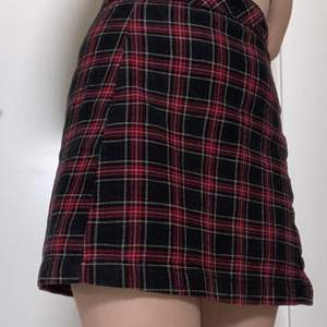 En kort röd kjol från hm. Knappar på sidan. Väl använd men har lyckats bevara den väl :)