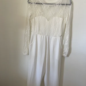 Spets jumpsuit med öppen rygg - Jätte fin jumpsuit med öppen rygg. Använd en gång och är insydd i midjan då den var lite för stor för mig. Perfekt till student/dop/ bröllop!