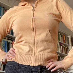 aprikos zipup - Säljer denna aprikos/orangea zipup hoodien. Den är tunn alltså inte så värmande men i fint material och hyfsat oanvänd! den angivna storleken är XS (jag är ungefär S eller M ibland  i vanliga fall)