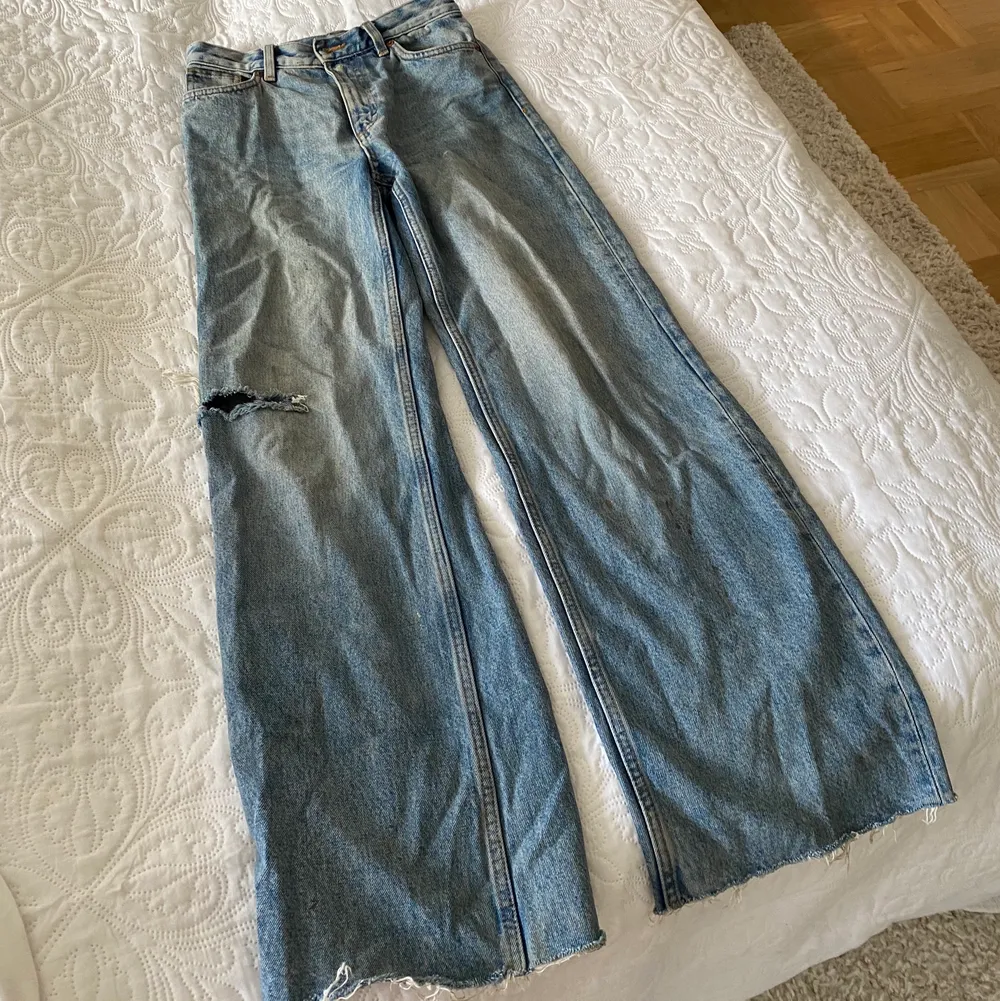 Fina utsvängda jeans från MONKI med slitning på sidan av benet. Väl använda och därmed har dom en liten fläck längst ner på benet. Jeans & Byxor.