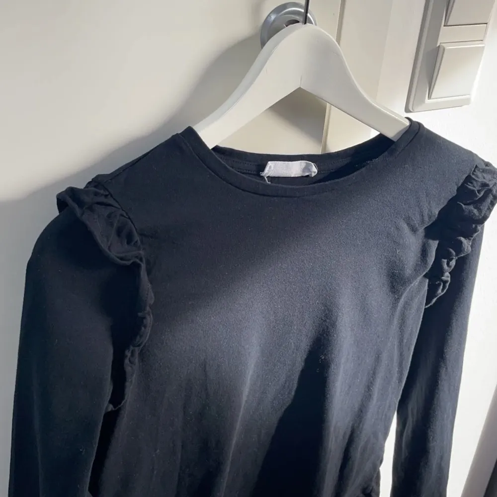 En fin svart långärmad tröja med små volanger på axlarna, har använt en gång men säljer då det inte är min stil. Köparen står för fraktkostnaden . Tröjor & Koftor.