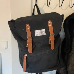 En liten ryggsäck perfekt att bära med sig mindre saker i. Väskan är ifrån lager 157 och liknar en gympapåse inuti, dessutom med rymliga fack på utsidan.