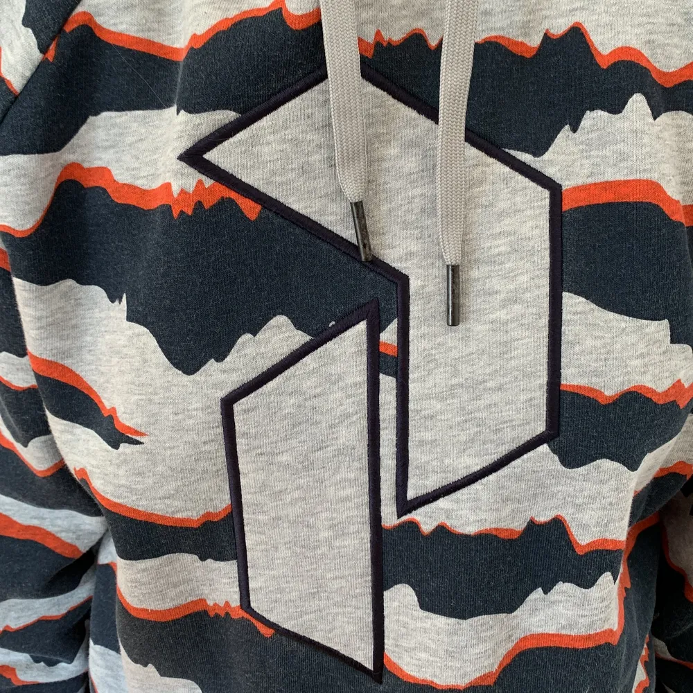 En grå/blå/orange hoodie, Peak Performance hoodie. Storlek L, passar oversized. Bra skick och skönt material!. Hupparit & Collegepaidat.