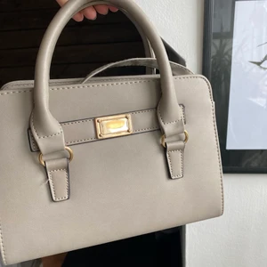 Grå handväska  - Fin grå handväska med gulddetaljer, med både långa och korta band:)