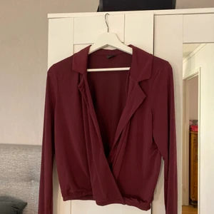Blus - En vinröd fin blus med en urringning framtil från GinaTricot i storlek S. Säljes för 30 kr+frakt