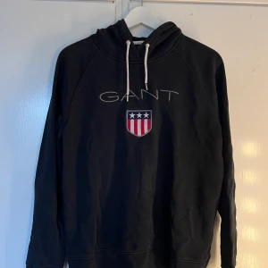 GANT hoodie - Mörkblå hoodie från GANT, använd men i bra skick. Endast snörena som fått missfärgning men inget man märker.  