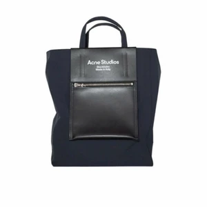ACNE STUDIOS papery nylon tote bag  - Svart shoppingväska med logotyptryck på framsidan, dragkedjeficka på framsidan och justerbar axelrem.  Mått: Höjd 33 cm x bredd 26 cm x djup 12 cm.  Nypris: 4400:- 