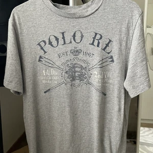 En grå t-shirt - Jag säljer en grå Polo Ralph Lauren t-shirt i storlek 160 men passar som XS/S. Säljer då den inte kommer till användning och känner att den är värd att sälja. 