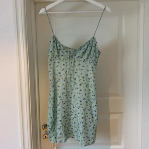 Söt kort klänning från Morel, storlek M - Kort klänning från märket Motel, köpt från Nelly.com. Den är ljusgrön med blåa blommor. Supersöt under en skinnjacka till ett par dr.Martins kängor. Storlek M. Dragkedja i bak. Använd men i bra skick. 