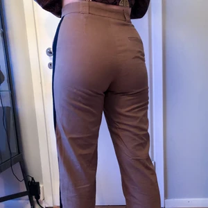 BYXOR - Stockholms ateljéer / & Other stories - Snygga bruna byxor med svart streck ner på vardera sida av benet. Från Stockholms ateljéer/ & other stories - bra material - hög i midja
