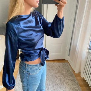 Satin topp - Blå Satin topp som man kan ha på lite olika sätt (se bilder) Köptes här på Plick och lappen finns ej kvar så vet ej märke.