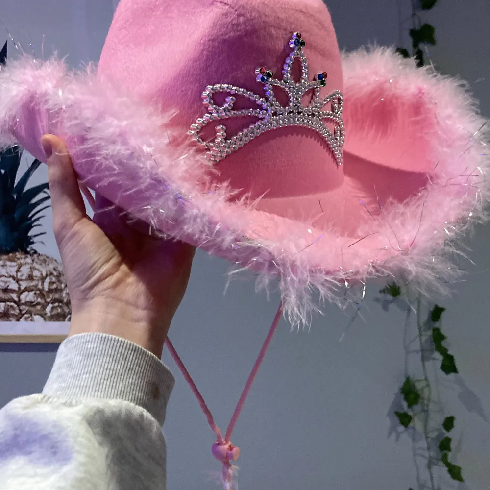 Fin cowboy hatt i färgen rosa. Tiara på och ludd på sidan. Snöret kan justeras! Jätte fin och gullig men säljs pga ingen användning. Fin dekoration i rummet och 🫶🏼 köparen står för frakten 💓. Accessoarer.