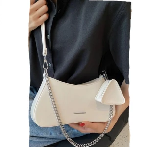 Beige väska - Ljusbeige/benvit väska från JFR(bild 1 lånad). Kan bäras antingen över axeln med kedjan, eller med väskbandet som medföljer. Ingår även en liten triangelformad coinpurse(bild1). Väskan är i nyskick💞Frakt: 66:- spårbart