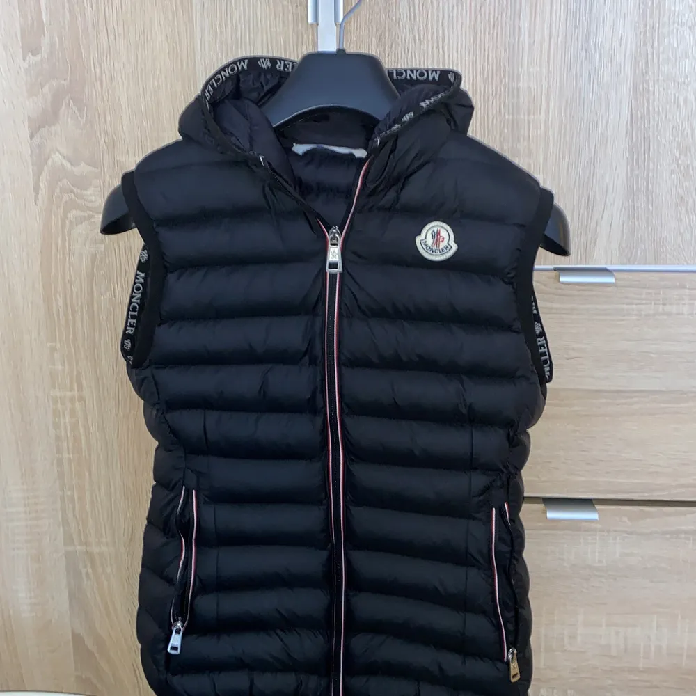 Moncler väst med luva i storlek 0 passar storlek XS-S. Använd endast 1-2 gånger, säljs pga ingen användning. Fick västen i present och säljs därför för 500kr, scanner finns i inner västen. Frakt står köparen för. Tar endast swish. . Jackor.