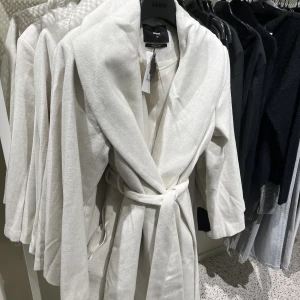 NY KAPPA BILBOK STRL XS - Säljer denna superfina kappa från Bikbok i storlek XS. Jag har tappat kvittot så kan inte lämna tillbaka, Superfin färg och lappen är kvar! 💕💕💕 färgen är vit/ljusgrå med inslag av beige. Nypris 899kr