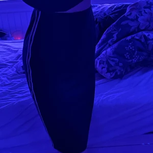 Kjol xs - Svart kjol med röd och vita sträck på sidan, tajt och lång! Jätte fin men används för lite! 