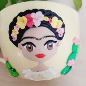 Frida kahlo inspirerat, handgjord, polymerlera figur på gul mugg 