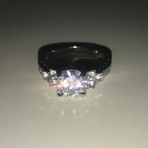 Jättefin silver ringa. En stor ”diamant” och tre små på varsin sida 
