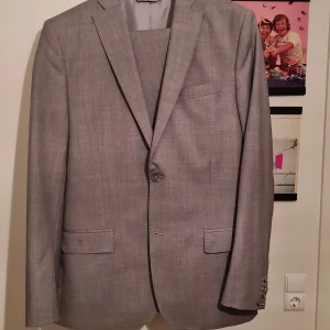 J.Lindeberg kostym - Grå kostym, använd 1 gång. 2 knappars knäppning, engelskt snitt, slim fit storlek M eller 50R R för regular.