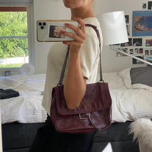 Röd väska - Så snygg vinröd väska från Zara! Går att ha både över axeln och som crossbody. Ca 20x 25 cm. Några enstaka slitningar och fläckar på innerfodret men inget man tänker på eller stör sig på, skriv för fler bilder! 💋