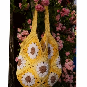 Virkad väska - Gul - Granny square väska gjord i bomull och akrylgarn med blandade nyanser av gult💛 Väskan är ca 28 cm i bredd och ca 28 cm i längd. Räknar man med axelremmen är väskan 52 cm i längd totalt🌼 (Lång axelremm) Frakt ej inräknad i priset💛