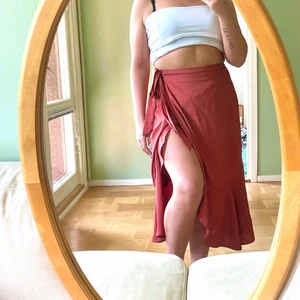 Omlottkjol röd - En längre omlottkjol i rödbrun färg! Spänns smidigt med både knapp och midjebandet och passar då även mindre storlekar.