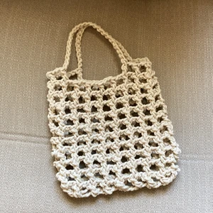 Liten virkad nätväska - Helt nygjord nätväska i 100% bomull. Väskan är lika lång som ett huvud ungefär och rymmer lätt två vattenflaskor. Garnet som väskan är gjord av är mycket starkt och går inte sönder så lätt.