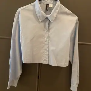 Ljusblå croppad skjorta från H&M.  Använd fåtal gånger.  Storlek S men passar bäst en 34.  Ord pris 99kr
