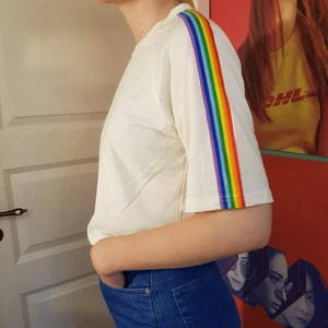 Crop top - Vit crop top med regnbåge längs ärmarna.