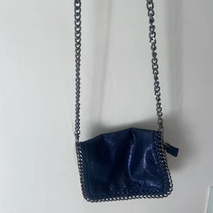 Glittrig väska - Säljer denna fina liknande Stella McCartney väska i en blåglittrig färg. Väskan är i fint skick💕