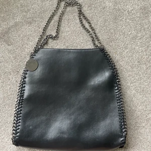Stella mccartney väska - Jätte fin populär stella mccartney väska, jätte bra t.ex skolväska då du får plats med mycket. Säljer pga ingen användning. Väldigt bra skick då den nästan inte är använd, kom privat för fler bilder♥️♥️