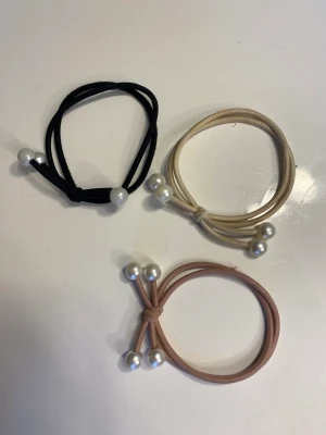 Söta hårsnoddar  - Hårsnoddar med vita pärlor vid slutet av bandet. 