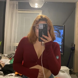 Vinröd topp - V-ringad, vinröd långärmad tröja från Kikiriki. Köpt i en Chiquelle affär. Storlek S men passar M också då den är stretchig.