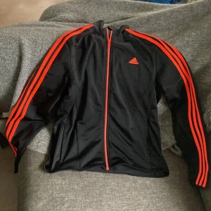 Adidas tröja - En svart adidas tröja med neon oranga detaljer. Storlek S Den användes ungefär 2-3 gånger, den är inte sliten alls! Vill bara bli av med de👍