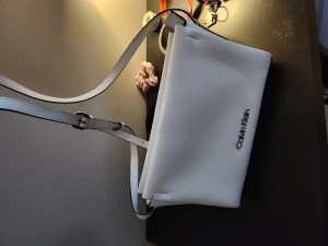 Väskor - Fina och knappt använda väskor.  Svart michael kors väska, 1500kr Vit calvin klein axelväska 800kr 