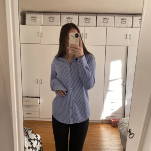 Randig skjorta  - En blå och vit randig skjorta från dressman. Sitter lite oversize på mig och är så fin till sommarkvällarna. Jätte fint skick utan några defekter. Köparen står för frakten💗