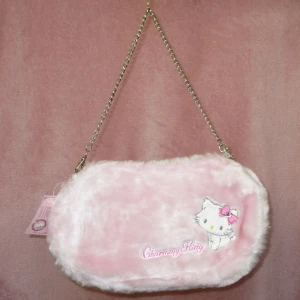 Sanrio Charmmy Kitty väska  - Hur söt väska?! Köpt från Japan men aldrig använt :( Storleken är ca: 28cm X 17cm X 3cm. Tyvärr lite tecken på åldrande (bild3) då väskan är från 2005. Men helt oanvänd annars! Köptes för 350kr men säljer för mindre pga de spruckna kanterna. 