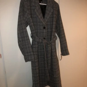 Rutig kappa - Rutig kappa från Lager 157 i storlek S. Finns inte kvar i sortimentet. Fungerar både på hösten och våren då den är lite tjockare och värmer lite. Endast använd en gång så i nyskick. 