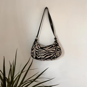 Zebra väska  - Älskar den här väskan men kommer tyvärr inte till användning. Super fin och mjuk. I den här väskan kan man få plats med mobil, laddare, smink, hörlurar och kort💕