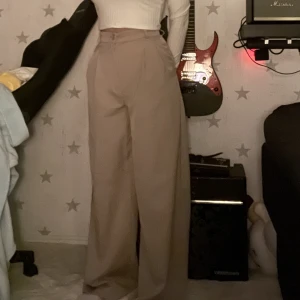 Beiga kostymbyxor  - Säljer dessa byxor från Monki då de inte är min stil🤎Använda 2 gånger och inga defekter vad jag ser🤎De sitter lite tajt i midjan på mig som har 64-65cm i midjemått (de sitter liksom precis runt min midja)🤎De har tyvärr inga fickor🤍Jag är 160cm lång🤍